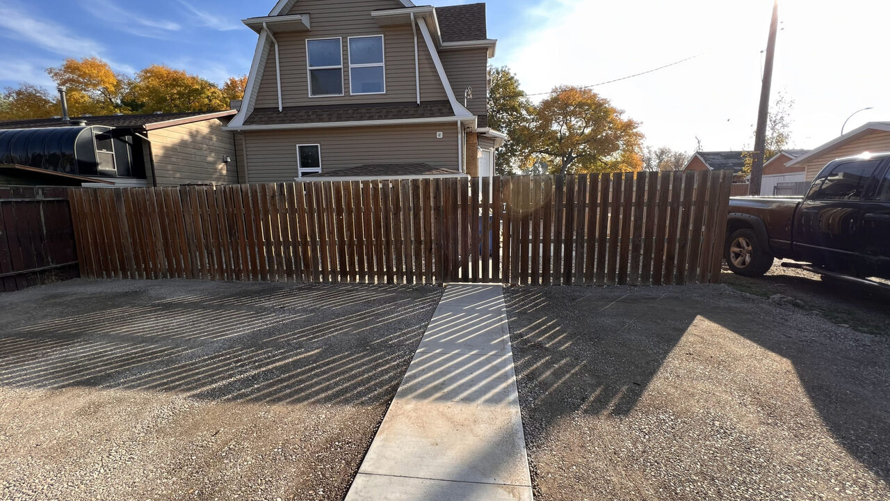 Concrete walkway leading to a fence in Lethbridge