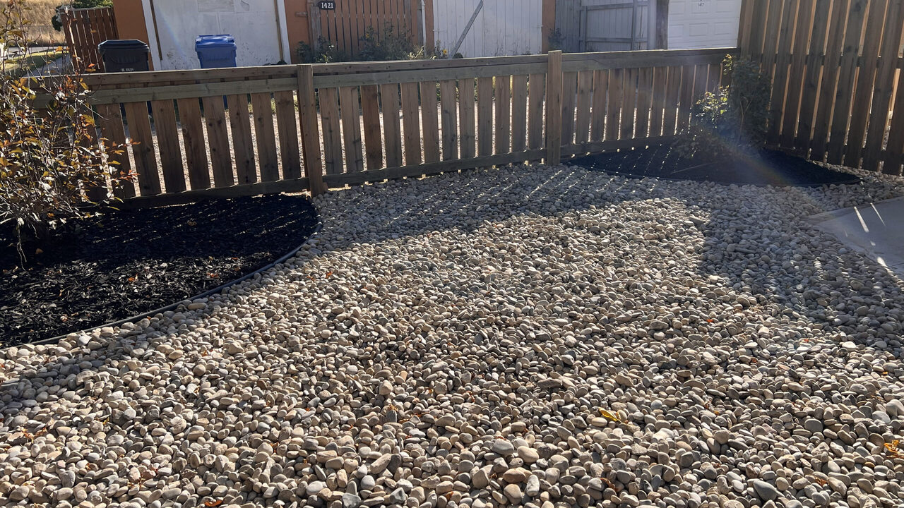 rock-to-fence-scaled Rock landscaping running to a fence line in Lethbridge